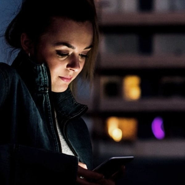 A woman using her phone in the dark