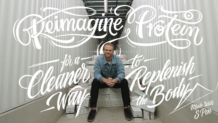 The Co-Founder and CEO of Après, Sonny McCraken sits on a pile of boxes containing his product. There is handwritten script overlayed on top of the photo that reads: "Reimagine protein for a cleaner way to replenish the body. Made with S Pen".
