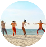 Des filles sautent sur une plage.