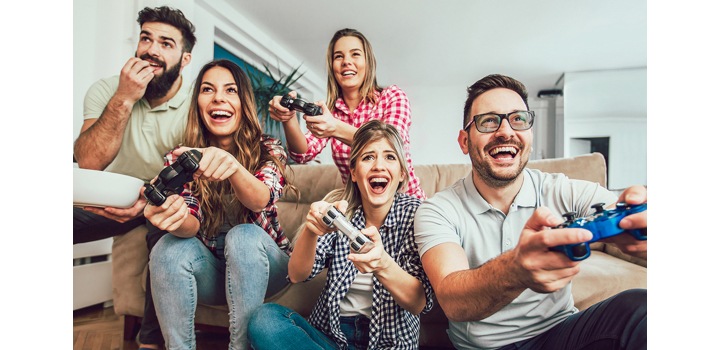 Avec un téléviseur grand écran, qui offre la meilleure taille pour le jeu, un groupe d’amis s’amuse tout en jouant sur une console de jeu.