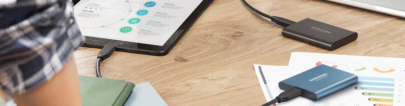 Portable ssd on desk connected to laptops