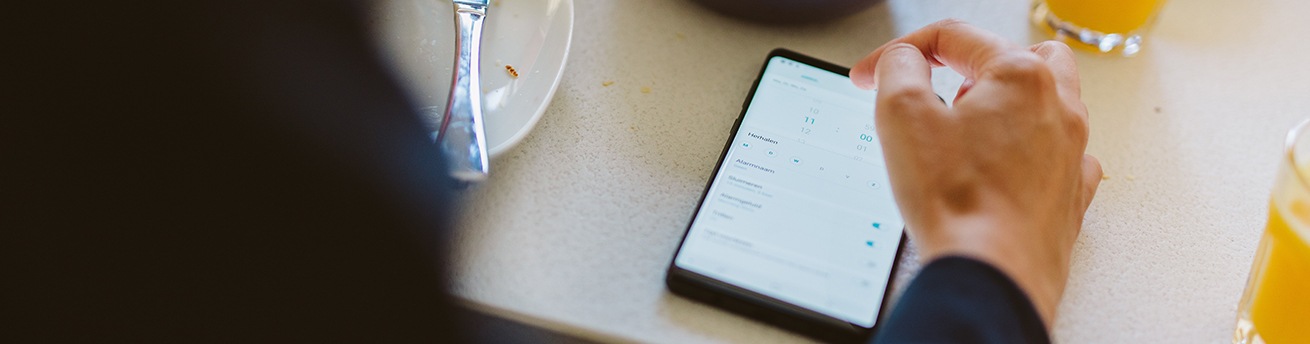 Person checking calendar on Galaxy Note9 during breakfast