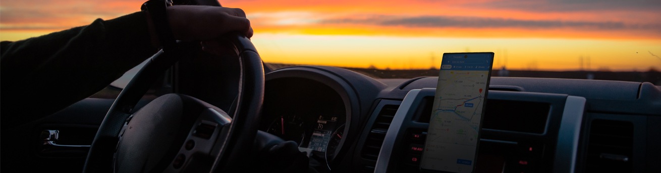 person driving in a car with a smartphone navigation on