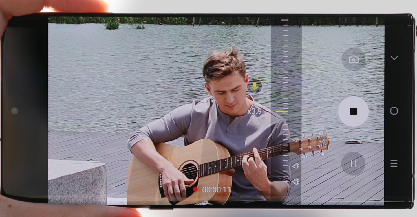 Un homme se fait filmer par un Samsung Note10 avec la fonction Zoom-in Mic pendant qu’il joue de la guitare