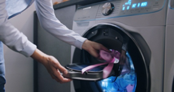 Een afbeelding waarin een kledingstuk nog toegevoegd wordt aan de was, in een Samsung QuickDrive™ wasmachine.