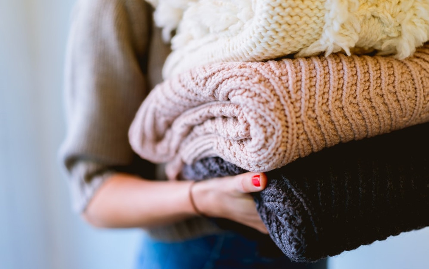une femme tient une pile de linge