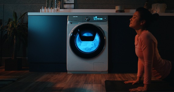 Une image de lave-linge Samsung QuickDrive™ dans une chambre sombre. Grâce au 3D Vibration Sensor, la machine produit moins de bruit. Elle peut donc également fonctionner la nuit.