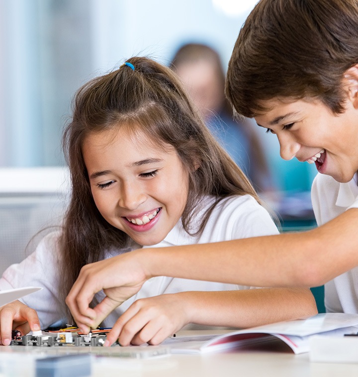 A boy and a girl working with technology
