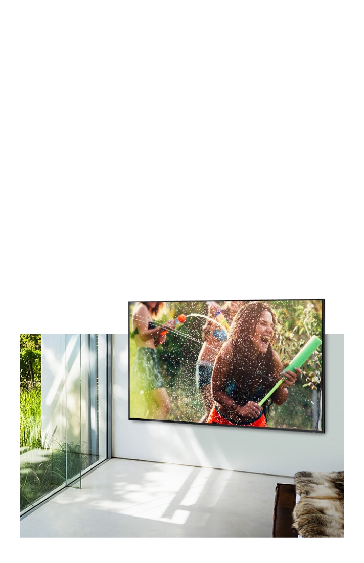 Een TV hangt aan de muur in een woonkamer en op het scherm zijn mensen te zien die een watergevecht houden. De TV is ingesteld op Standard Mode en geeft een hoge resolutie beeldkwaliteit.