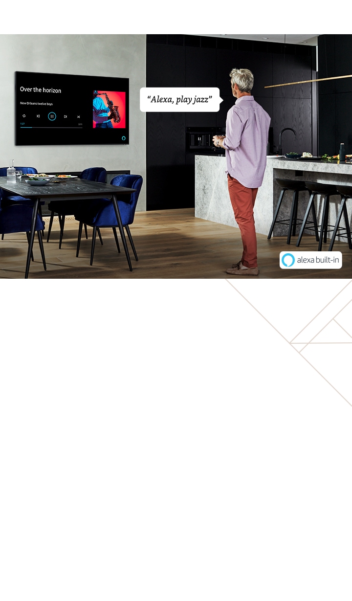 2020 Samsung QLED has built-in Alexa which does not need a Amazon Alexa device separately. A man who is standing is telling "Alexa, play Jazz" and onscreen is showing the art album.