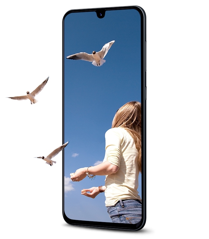 Galaxy A in portrait mode showing a woman releasing birds that fly off the screen to show the immersion of the Infinity Display.