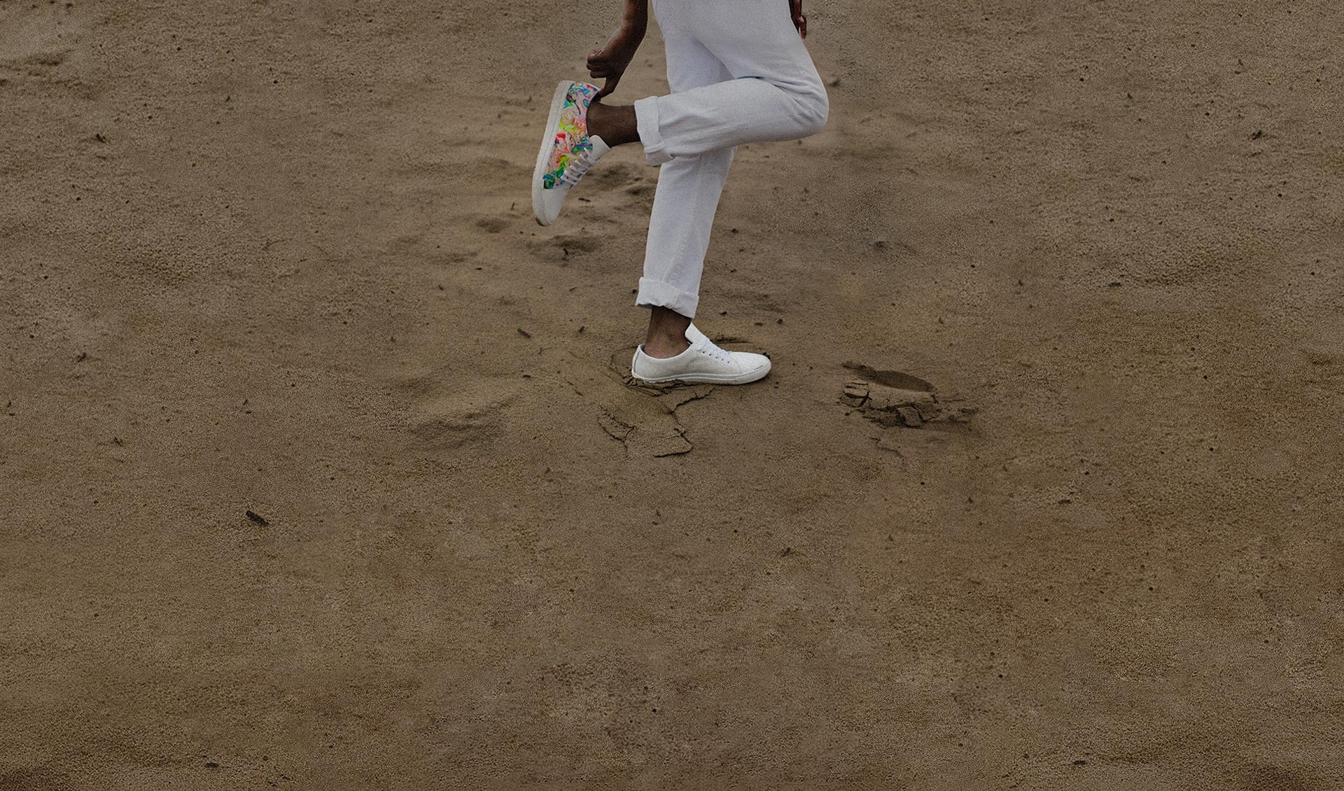 Photo of a person who is wearing sneakers holding up one foot