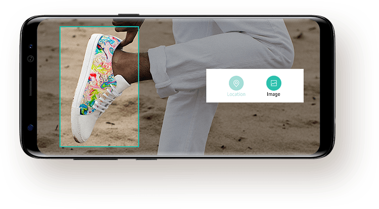 Photo of a person who is wearing sneakers holding up one foot on the screen of Galaxy S8 with messages from user to Bixby asking to search for similar sneakers online