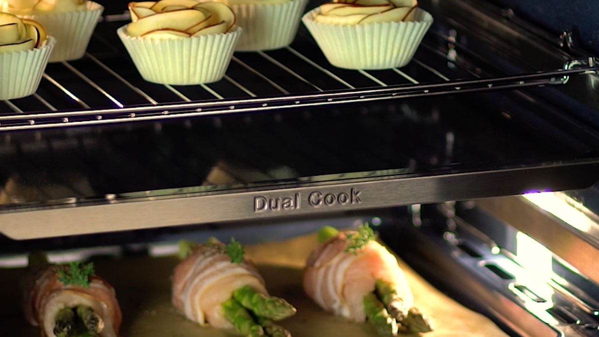 W piekarniku Samsung Dual Cook upieczesz jednocześnie roladki z jabłkami i roladki z kurczaka ze szparagami w różnych trybach pieczenia. W piekarniku Samsung Dual Cook upieczesz jednocześnie roladki z jabłkami i roladki z kurczaka ze szparagami w różnych trybach pieczenia.