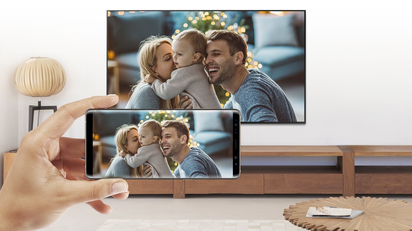Mobile Phone and Smart TV sharing a same screen; photo of parents and a child.