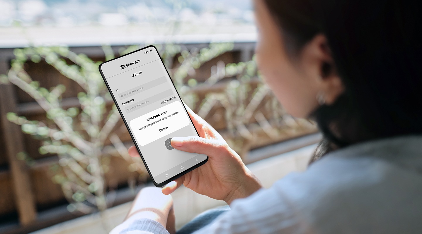 إحدى مستخدمات الهاتف الذكي من Galaxy تستخدم بصمة إصبعها لمصادقة رسالة منبثقة من تطبيق Samsung Pass لتُسجل الدخول إلى تطبيق البنك الخاص بها.