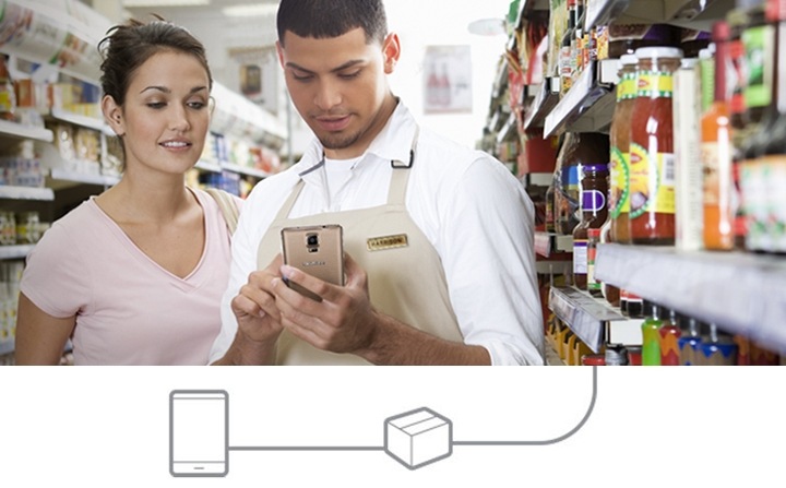 Um funcionário olha para um smartphone para ajudar o seu cliente