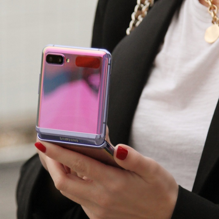 Galaxy Z Flip Galaki Z Flip u ogledalu ljubičasto preklopljen pod pravim uglom, gledano sa prednje strane, cvetnim cvetnim grafičkim pozadinama na ekranu