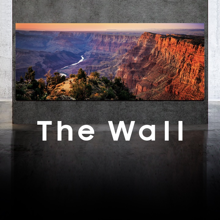 The Wall key visual image Samsung The Wall mounted on a large concrete wall with a grand view of a cliff at sunset