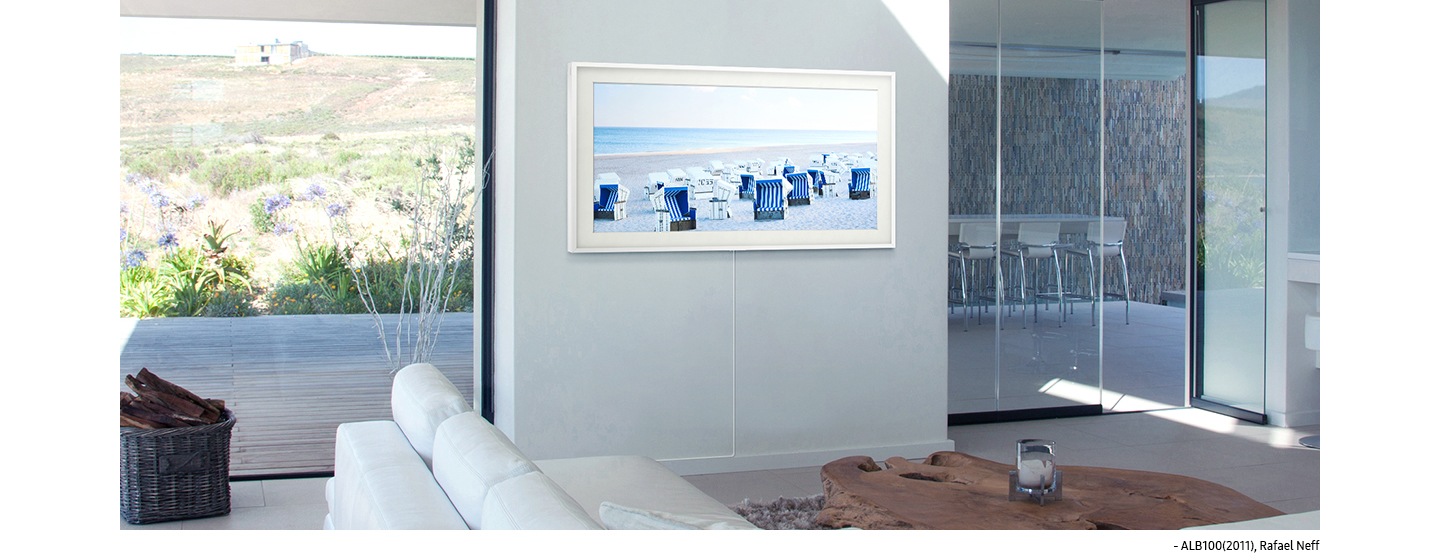 صورة تظهر The Frame وهو معلق على الجدار بدون مسافة فاصلة، حيث تعرض شاشته لوحة "ALB100 (2011)" لرافائيل نيف ، وهي صورة لواجهة المحيط الزرقاء مع كراسي شاطئ زرقاء وبيضاء متناثرة في المقدمة.