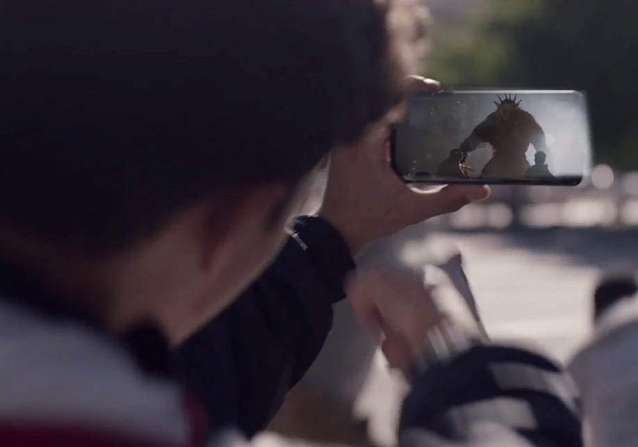 لاعب يستعد لالتقاط صورة الوحش العملاق المعروض على الشاشة عبر الواقع المعزز في جهاز Samsung Galaxy.