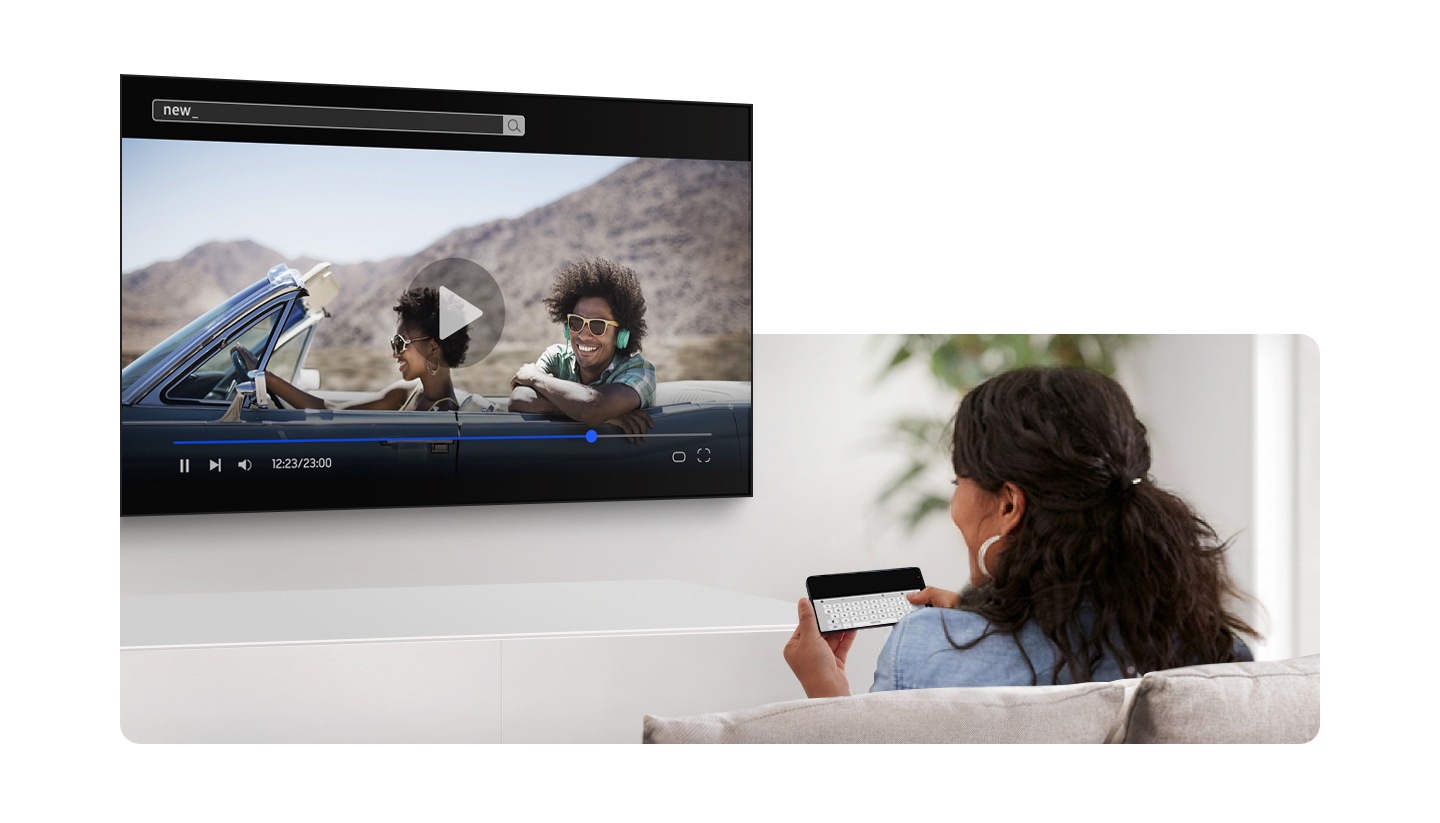 A woman watching a show on TV while using her smartphone's keyboard to type.