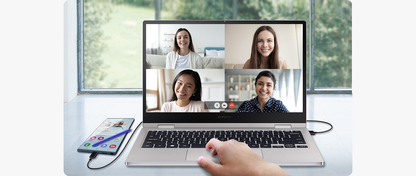 En smartphone är ansluten till en laptop. Laptopskärmen visar ett videomöte med fyra andra personer medan smartphone-skärmen visar en helt annan skärm.