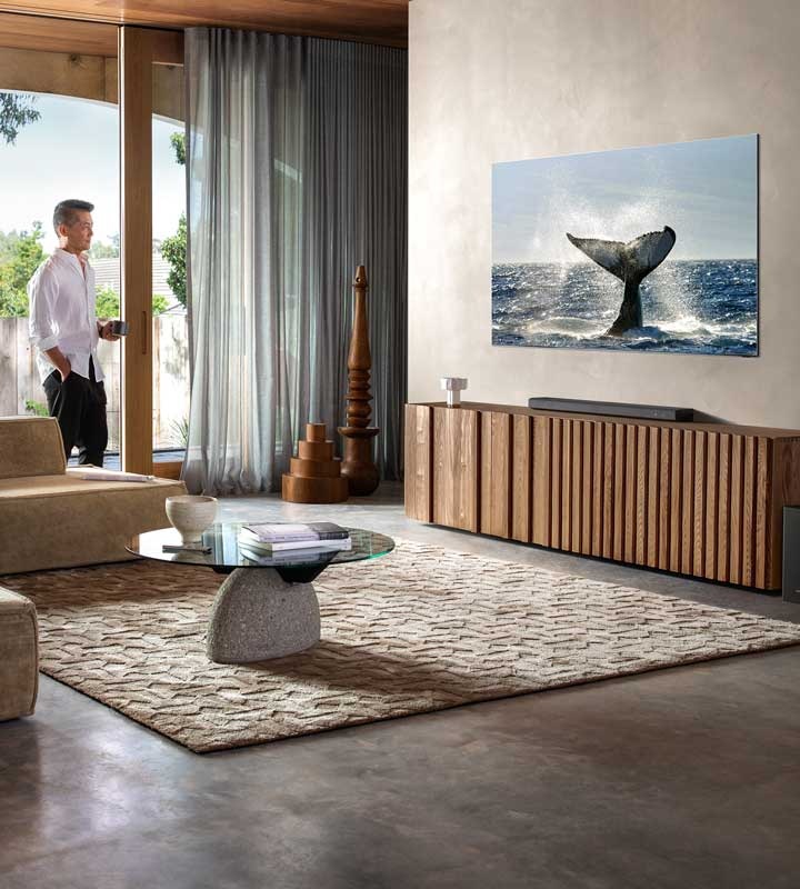 Kuva seinällä olevasta QLED-televisiosta ja soundbar