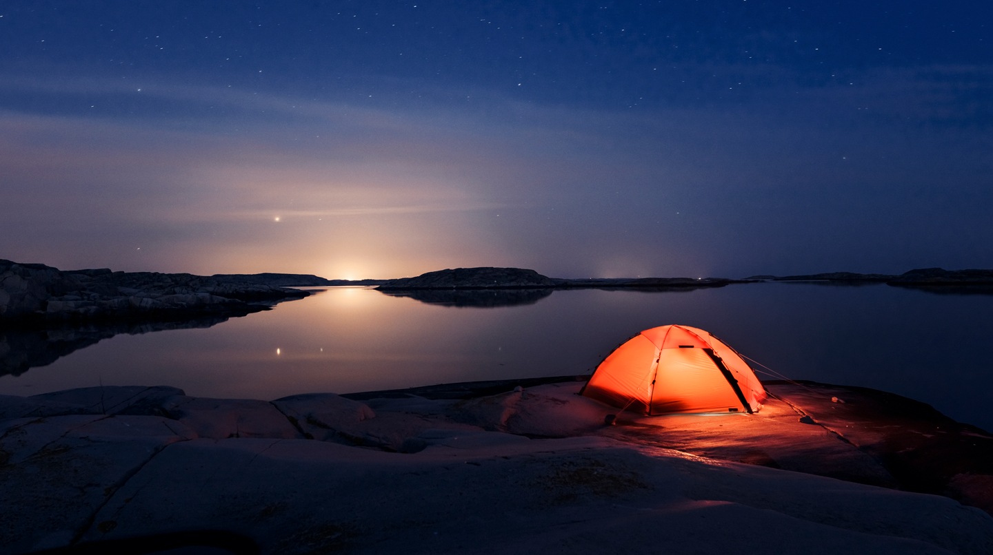 Image of a woman using her phone outside at night. A battery icon on the bottom right shows she has a most of her battery power left.