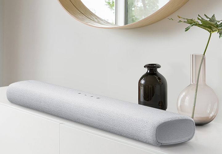 S-series soundbar S-series Soundbar ligger på en hvit skjenk med speil over.
