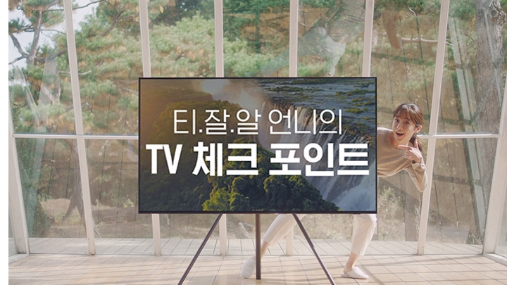 채광이 잘 들어오는 실내 공간 한 가운데에 TV가 있고, TV 화면에는 티.잘.알 언니의 TV 체크 포인트 텍스트가 적혀있습니다.