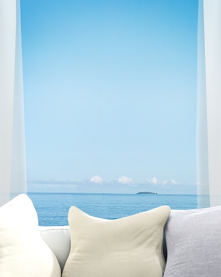 거실 창문 밖으로 보이는 파란 바다 이미지