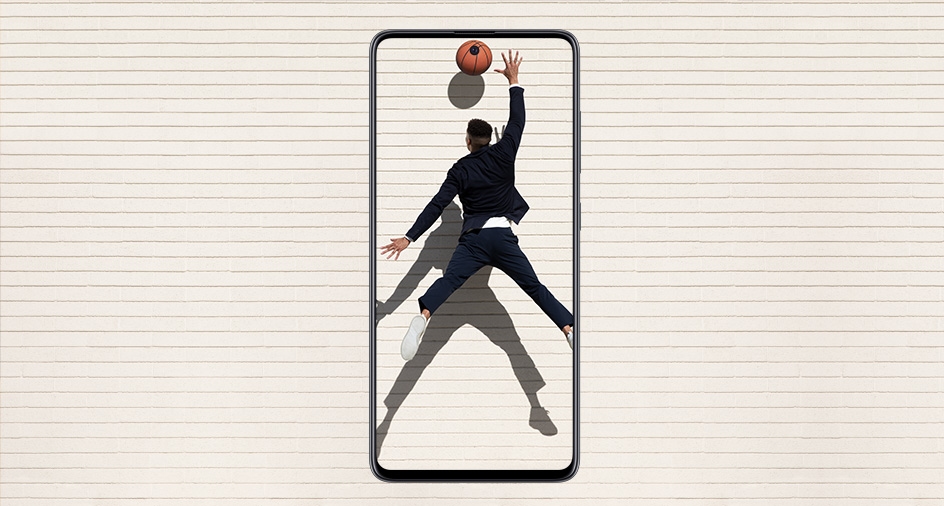 스마트폰 화면 안에 점프를 한 남자가 손을 뻗어 농구공을 잡으려는 모습이 담겨 있습니다.