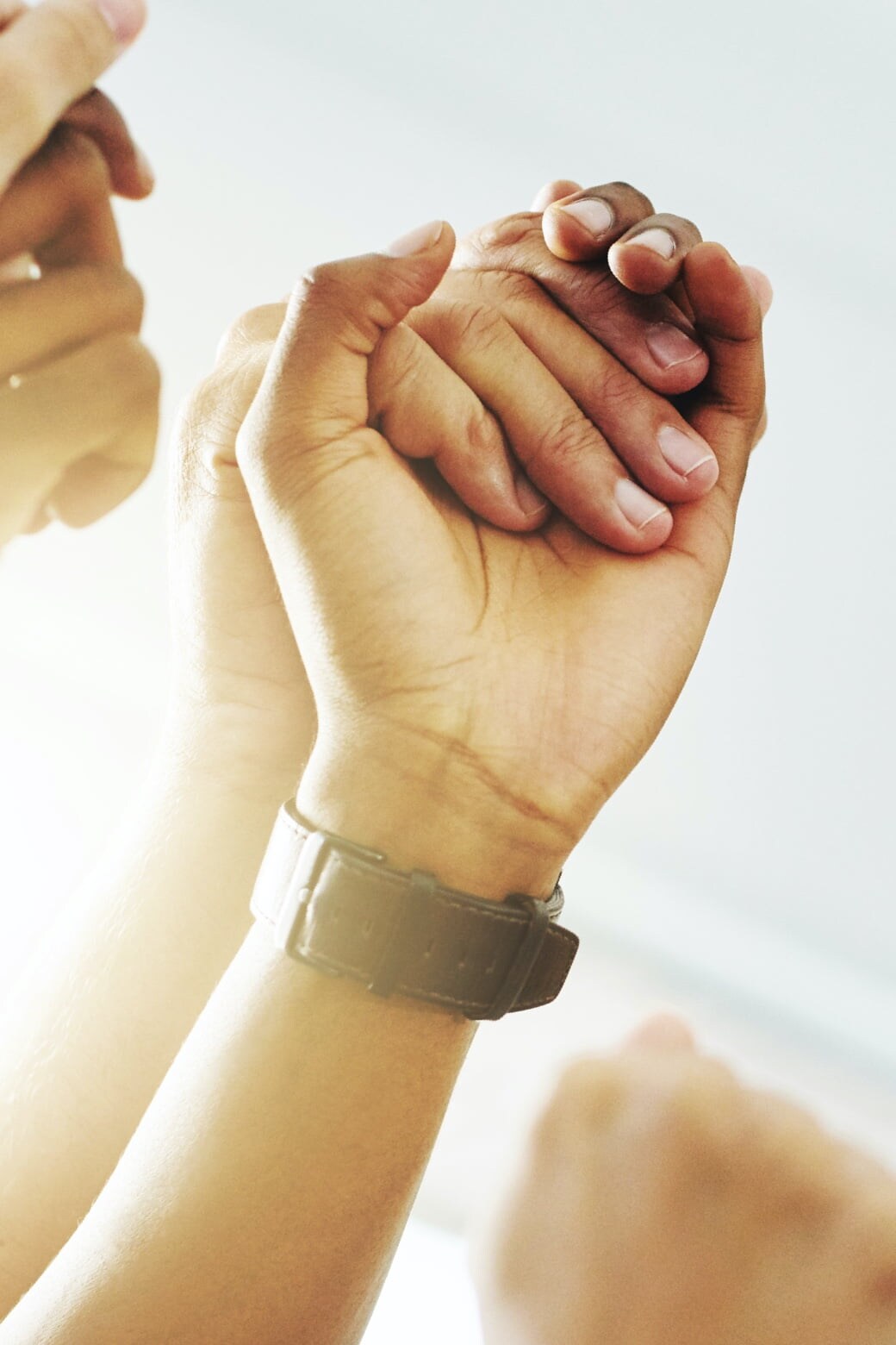 Close-up of multiple people holding hands.