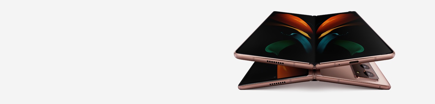 Two unfolded Galaxy Z Fold2 phones in Mystic Bronze, one laying face up and the other laying facedown. The one seen from the front is on top of the one seen laying facedown and has the butterfly wallpaper onscreen.