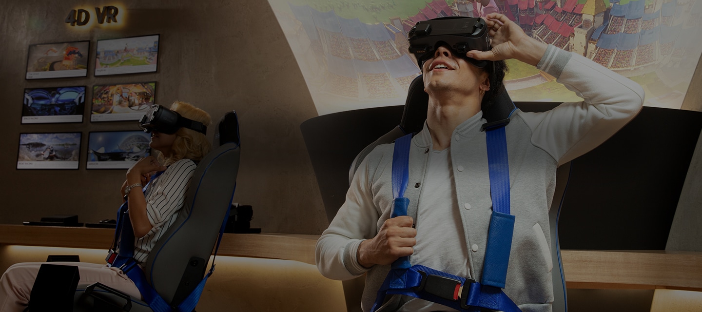A male and a female seated in separate seats, experiencing 4D VR inside a Galaxy Experience Store