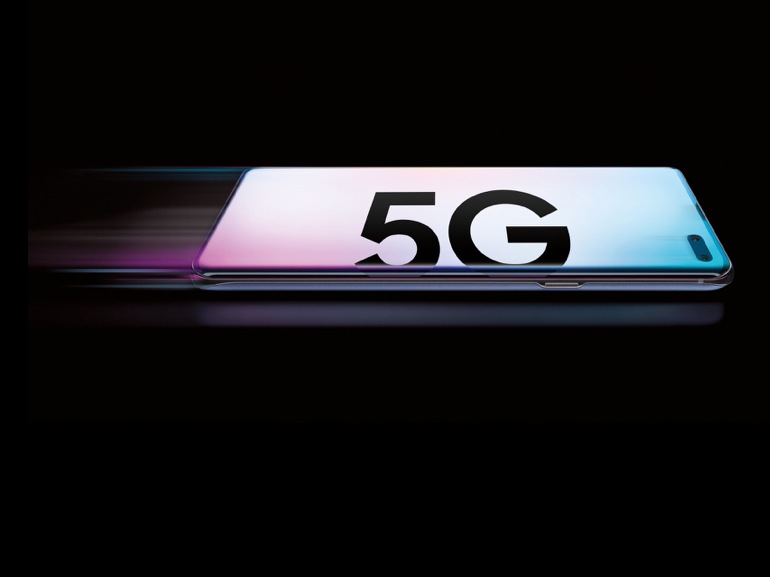 สมาร์ทโฟน Samsung Galaxy S10 สีฟ้าและสีชมพูพาสเทลวางคว่ำหน้าอยู่ โดยมีตัวหนังสือ "5G" ตัวหนาอยู่ตรงด้านหลัง