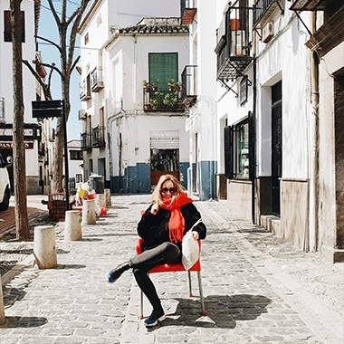 A photo captured with Galaxy by Instagram user @inescostamonteiro of a woman sitting on a red chair in the middle of a sidewalk