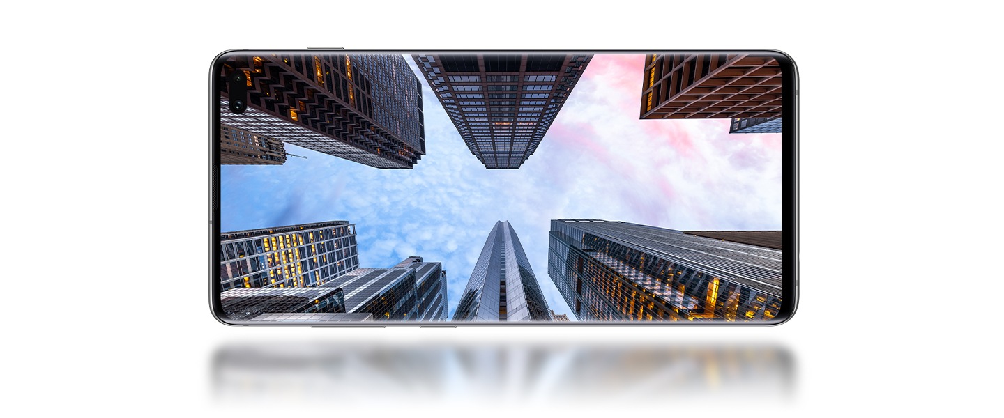 Galaxy S10+橫放,視角自前方觀看,螢幕上顯示出以灰暗天空為背景的摩天大樓照片。