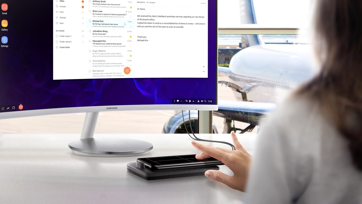 一位女性坐在桌前透過 Samsung Dex 連接Samsung S9或S9+畫面到顯示器上