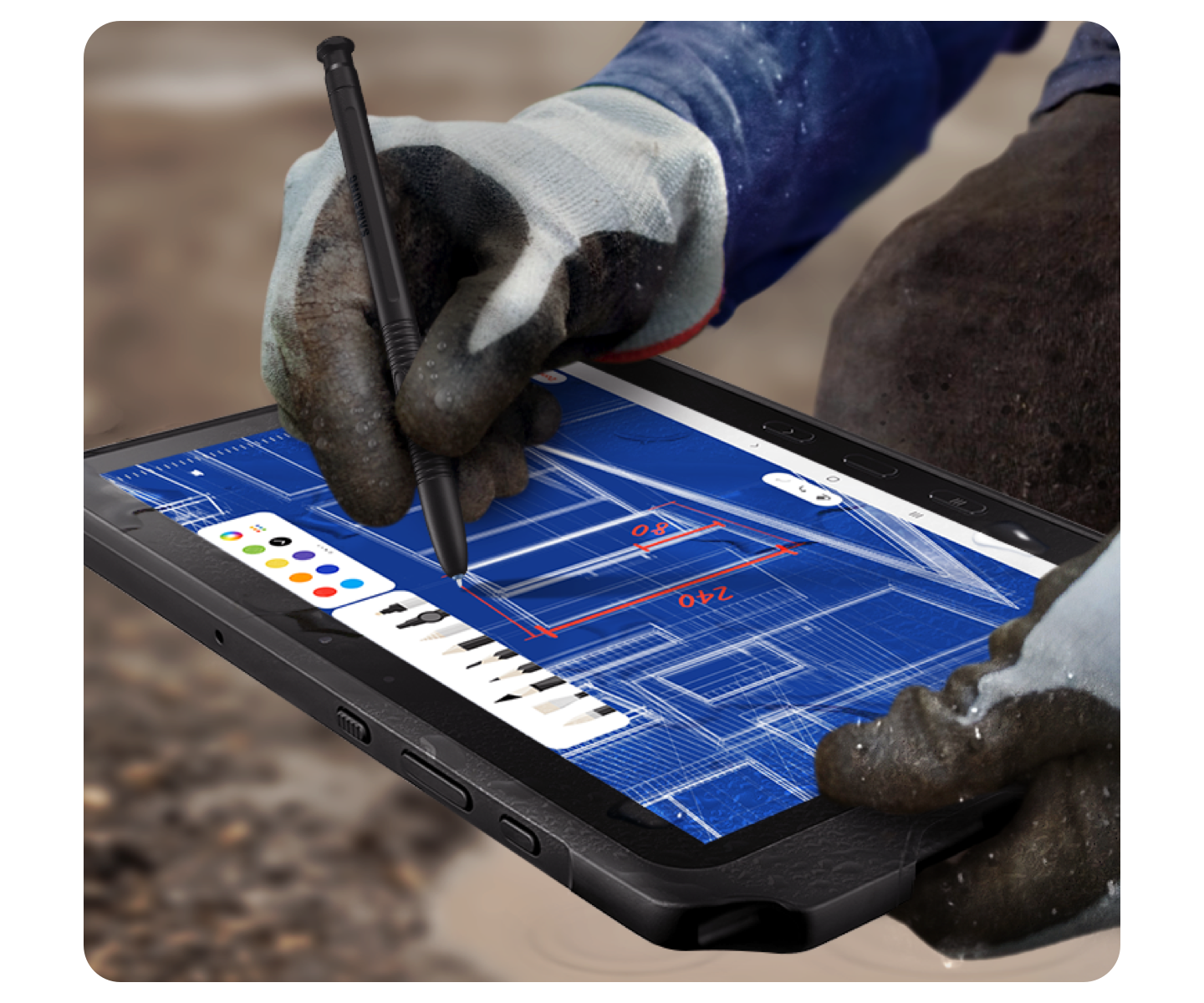 Two hands wearing protective gloves draw on a digital blueprint on a black, rugged Samsung tablet using a black S Pen