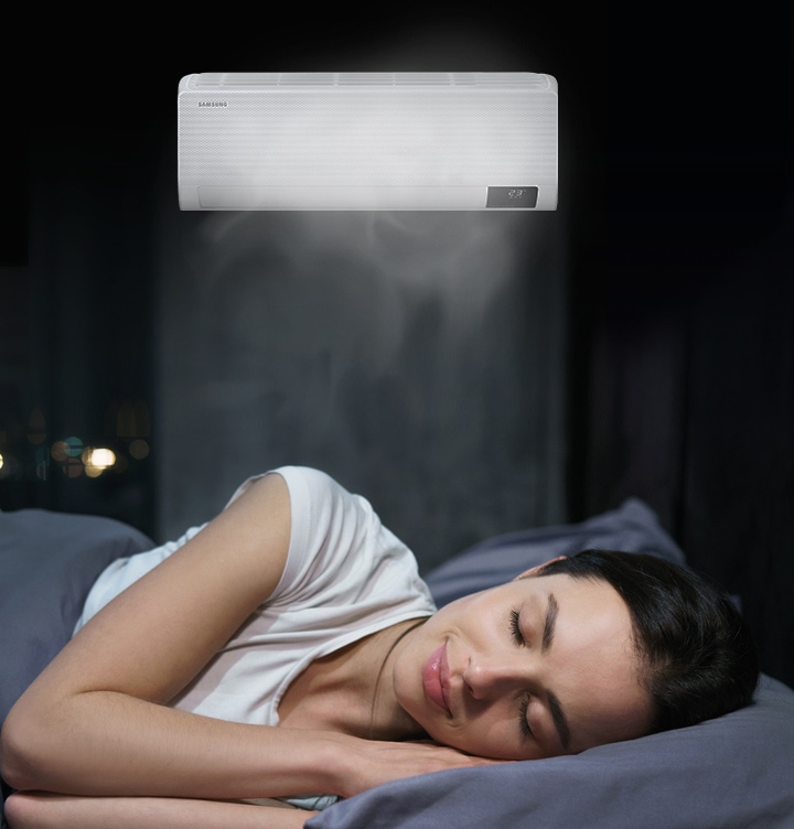 Woman relaxing in bed as Wind-Free technology enhances your indoor comfort by using thousands of micro-holes to disperse fresh air uniformly without any cold wind.