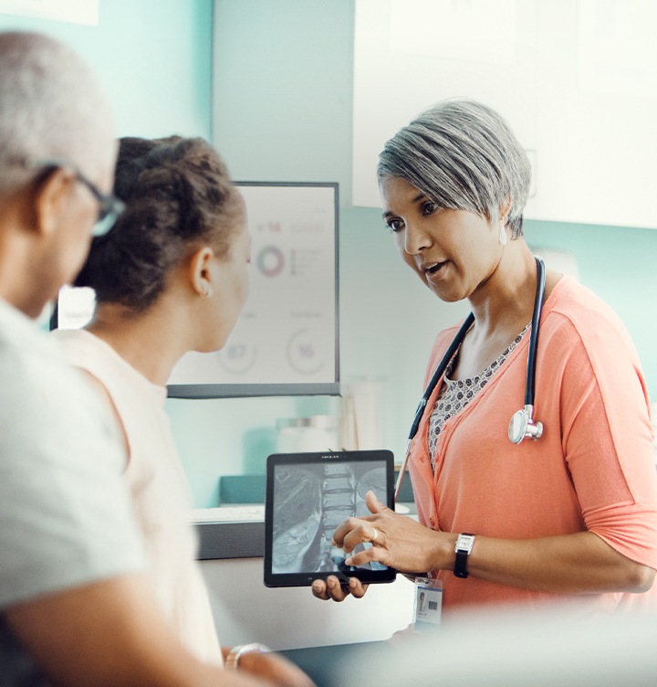 Imagen de un doctor sosteniendo una tablet Samsung y explicando algo a sus pacientes