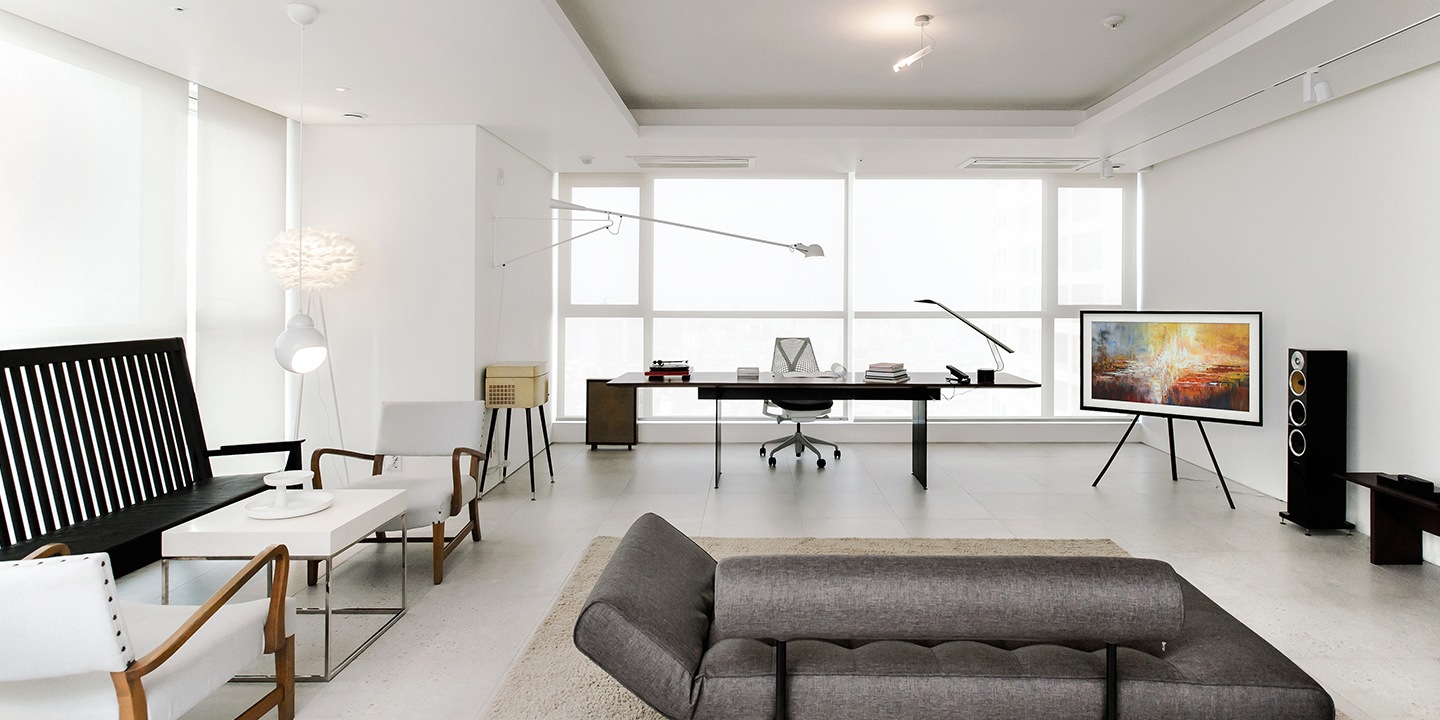 Una sala de estar bien iluminada con un televisor The Frame en un lateral de la habitación. La exhibición de arte del televisor brinda ideas de diseño de interior para un estilo de interior moderno.