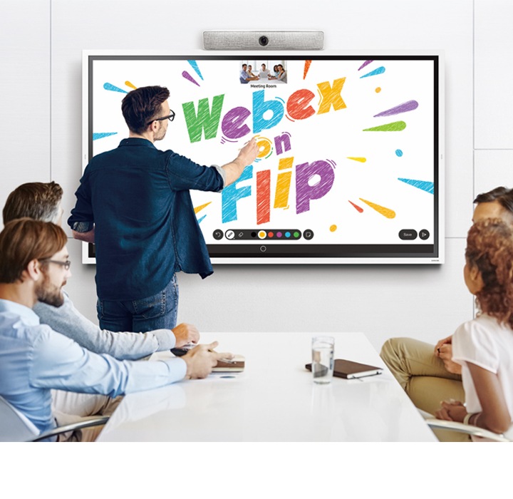 I ett konferensrum med fem personer står en man och skriver ”Webex on Flip” med bokstäver i olika färger på Samsung Flip-skärmen.