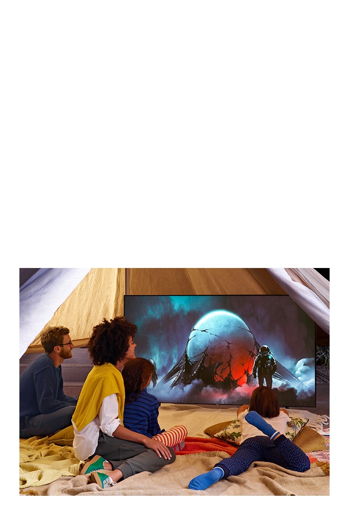 Un téléviseur grande taille placé sur le sol affiche un film sur le thème de l'espace avec le mode film des paramètres d'image du téléviseur Samsung qui offre une expérience de film immersive.