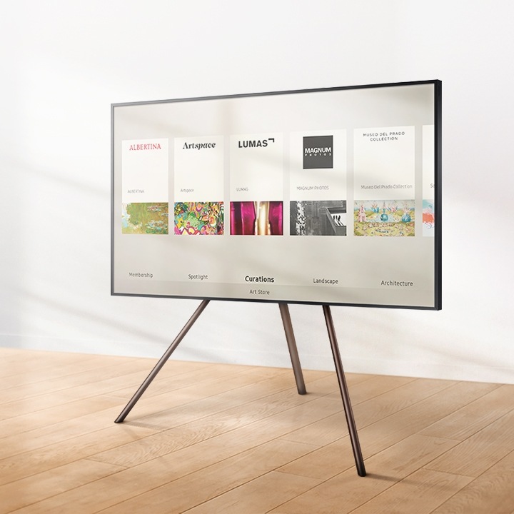 The Frame - TV Khung Tranh hiển thị danh sách Art Store với khung viền linh hoạt màu hạt dẻ và chân đế Studio.