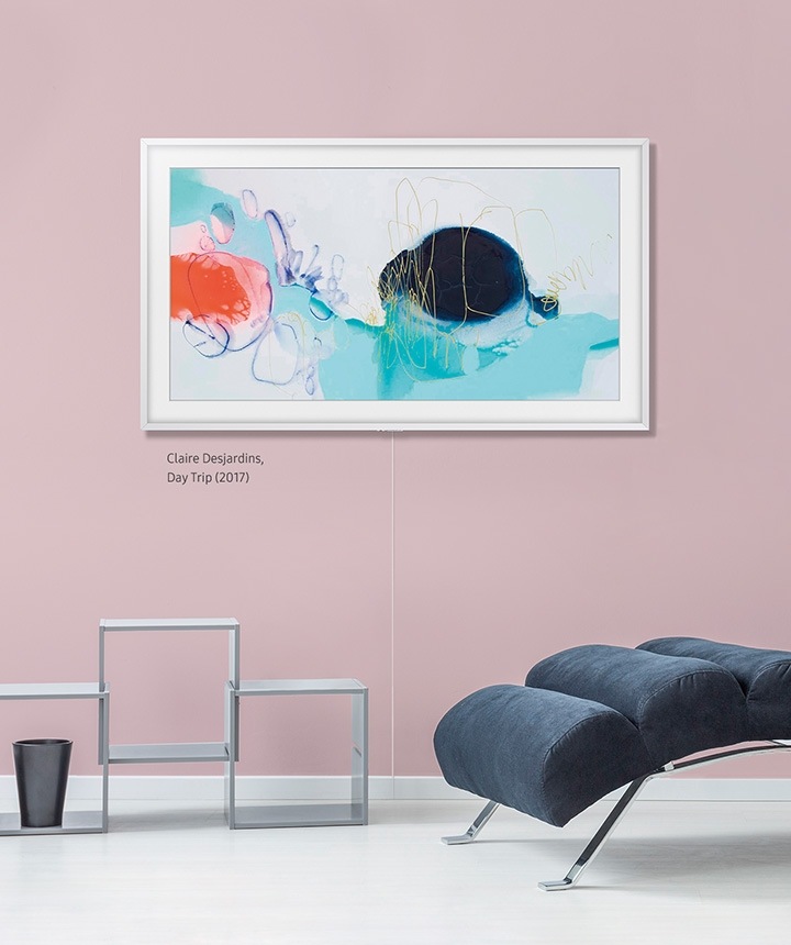 The Frame - TV Khung Tranh đang treo trên tường bên cạnh cái tủ hình khối với khung viền linh hoạt màu gỗ sồi.