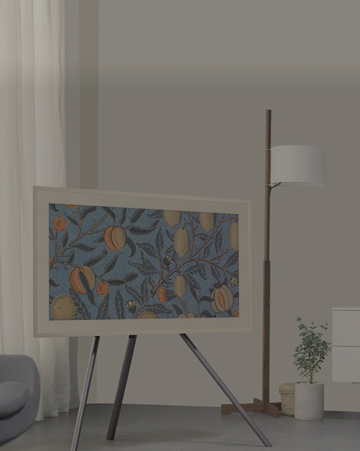 Samsung 2018 The Frame TV is in a cozy room. Being on a studio stand, the TV looks just like a real picture frame.