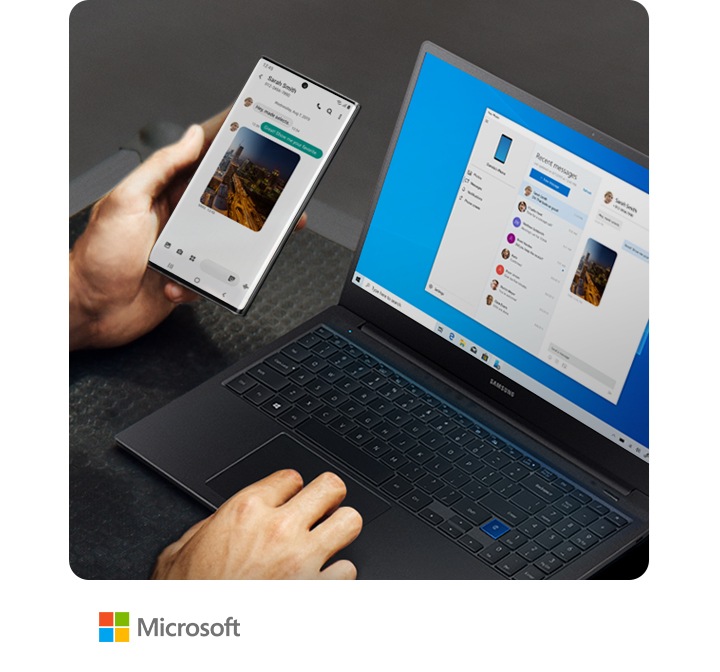 Man working on a laptop and holding Galaxy Note10+. Both the laptop and the phone have the same text message conversation onscreen, showing how Link to Windows syncs messages to your PC.